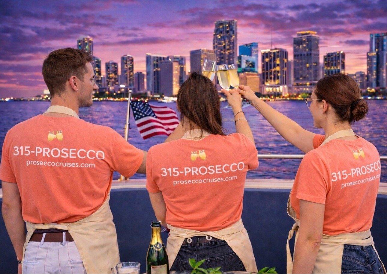 Prosecco Cruises crew toasting at sunset with Miami skyline